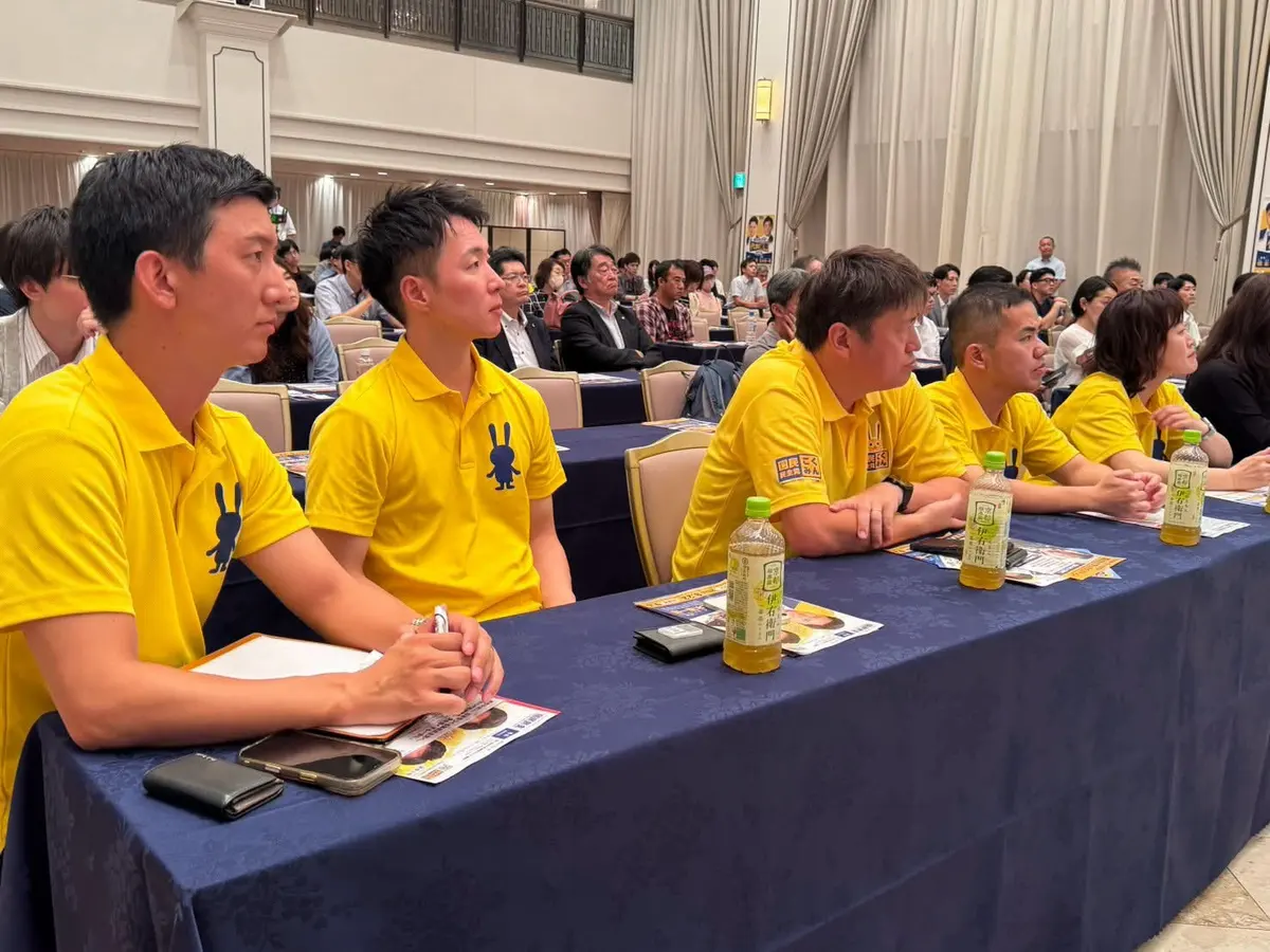 党の研修会で登壇者席に着く阿部恭介
