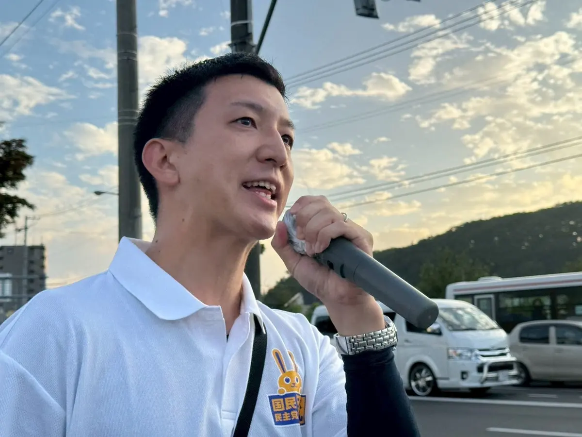 夕方の街頭でマイクを握って語りかける阿部恭介