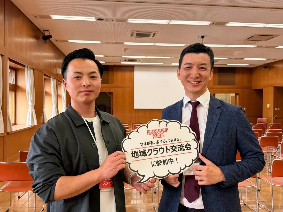 地域クラウド交流会の会場で参加者と並ぶ阿部恭介